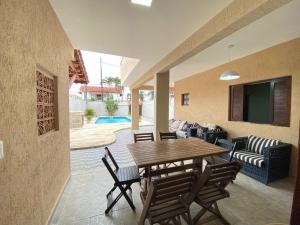 a dining room with a wooden table and chairs at Casa Pazim in Itanhaém