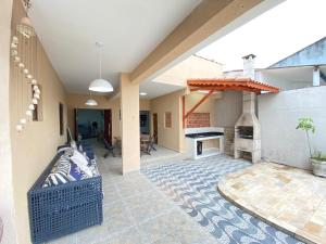 a patio with a couch and a fireplace in a house at Casa Pazim in Itanhaém