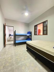 a bedroom with two bunk beds and a mirror at Casa Pazim in Itanhaém +11 photos