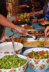 a group of people preparing food in bowls on a table at Wadi rum wanderlust camp in Wadi Rum