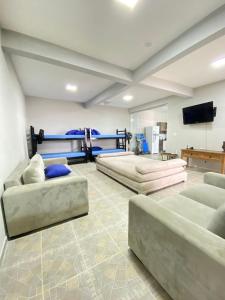a large room with two beds and a flat screen tv at Casa Pazim in Itanhaém