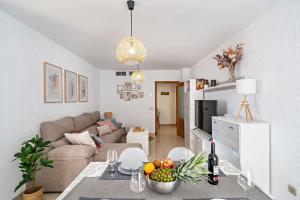 a living room with a couch and a table with fruit at Elegante piso en la Romanilla in Roquetas de Mar