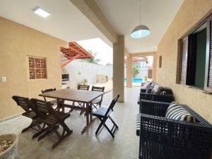 a patio with a wooden table and chairs at Casa Pazim in Itanhaém