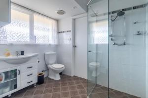 Un baño con inodoro y ducha de cristal. en Doug's Jetty - Sheets Provided, en Sussex Inlet 20 fotos más