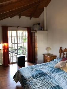 a bedroom with a bed with a blue and white blanket at Casas de alquiler FIKA in Capilla del Monte