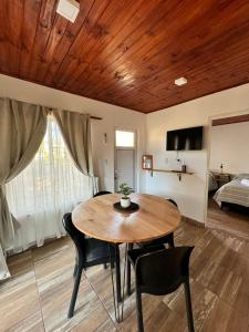a dining room with a table and chairs and a bed at Casas de alquiler FIKA in Capilla del Monte