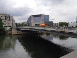 a bridge over a river in a city with buildings at Issy Citea Access dayuse Room - Work and Day Rest Timeshare -- 2 min tram - Formule Temps Partagé -- Navette ile d'Issy Avenue Paris 92320 espace nuit in Issy-les-Moulineaux