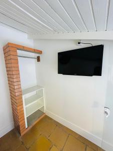 a room with a flat screen tv on a wall at Kitnet Centro Atlântida Sul in Xangri-lá