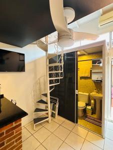 a room with a spiral staircase and a bathroom at Kitnet Centro Atlântida Sul in Xangri-lá