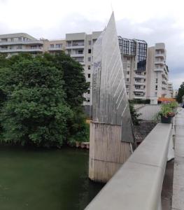 a bridge over a river with buildings in the background at Issy Citea Access dayuse Room - Work and Day Rest Timeshare -- 2 min tram - Formule Temps Partagé -- Navette ile d'Issy Avenue Paris 92320 espace nuit in Issy-les-Moulineaux