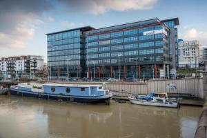 two boats docked in the water in front of a building at Issy Citea Access dayuse Room - Work and Day Rest Timeshare -- 2 min tram - Formule Temps Partagé -- Navette ile d'Issy Avenue Paris 92320 espace nuit in Issy-les-Moulineaux