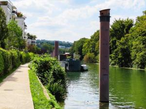 a boat on a river with a pole in the water at Issy Citea Access dayuse Room - Work and Day Rest Timeshare -- 2 min tram - Formule Temps Partagé -- Navette ile d'Issy Avenue Paris 92320 espace nuit in Issy-les-Moulineaux