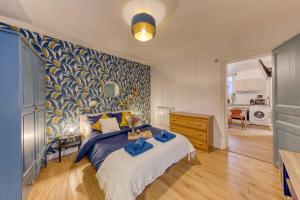 Le Zenith, le calme et l'élégance proche Paris et Stade de France في سان دوني: غرفة نوم بسرير وجدار ازرق وابيض