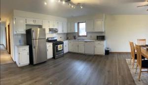 a kitchen with white cabinets and a table and a refrigerator at 3BR-2BA Deluxe Apartment with Fireplace and Balcony in Niles +6 photos
