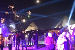 a group of people watching fireworks at night at The Heaven Pyramids View in Cairo
