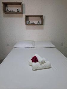 a white bed with a flower on top of it at Lar do Patacho in Pôrto de Pedras +10 photos