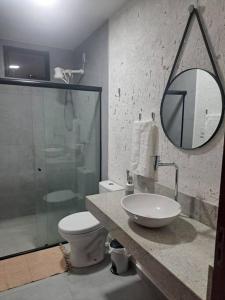 a bathroom with a sink and a toilet and a mirror at Lar do Patacho in Pôrto de Pedras