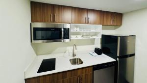 una cocina con fregadero y microondas en MainStay Suites Chambersburg, en Chambersburg