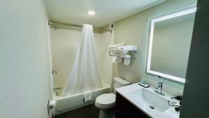 Un baño con inodoro, lavabo y ducha. en MainStay Suites Chambersburg, en Chambersburg