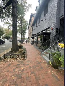 a brick sidewalk next to a tree next to a building at Dc Play House Bed and Breakfast in Washington