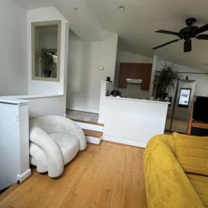 a living room with a white couch and a ceiling fan at Dc Play House Bed and Breakfast in Washington