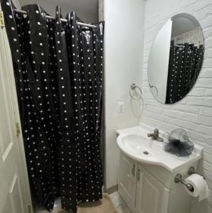 a bathroom with a black shower curtain and a sink at Dc Play House Bed and Breakfast in Washington