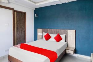 Un dormitorio con una cama grande con almohadas rojas. en Hotel O Sea View Inn, en Chennai