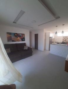 a living room with a couch and a kitchen at Apartamento na Praia do Guaibim in Ponta da Areia