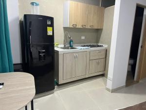 a kitchen with a black refrigerator and a sink at SWEET BREEZE in San Andrés