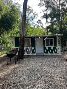 una cabina verde con un albero di fronte di Cabaña a Estrenar en Santa Ana a Santa Ana