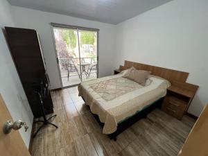 una camera da letto con un letto e un balcone con un tavolo di Cabaña a Estrenar en Santa Ana a Santa Ana