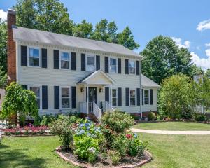 a house with flowers in the front yard at Kernersville King Beds Hot Tub Arcade Firepit in Kernersville