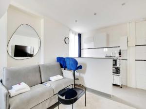 Una sala de estar con un sofá y un espejo. en Nice studio 2Pers - Villiers Batignolles, en París