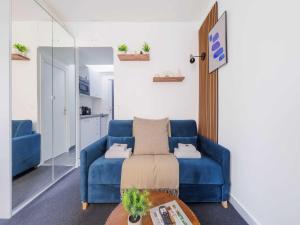 a living room with a blue couch and a table at Charming studio for 2 people - Mobility lease in Paris