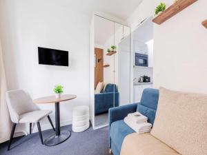 a living room with a blue couch and a table at Charming studio for 2 people - Mobility lease in Paris