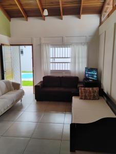 a living room with a couch and a tv at Casa e conforto in Itapoa