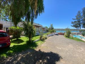 a house with a car parked in front of a driveway at Cabañas Villa Alegre in Lago Rapel