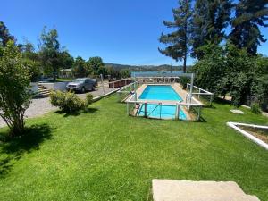 a yard with a swimming pool and a car at Cabañas Villa Alegre in Lago Rapel