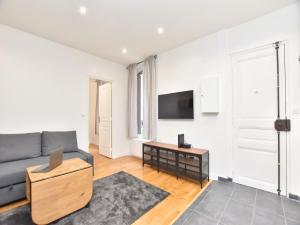 a living room with a couch and a tv at Modern flat - 1BR 4P - Puteaux La Défense in Puteaux