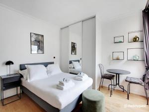 a bedroom with a bed and a table and a chair at Quiet and bright studio - 2P - Rueil Malmaison in Rueil-Malmaison