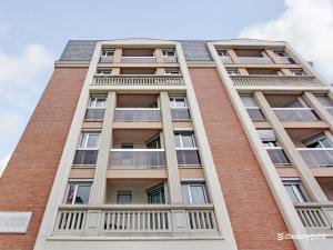 a tall brick building with windows on it at Quiet and bright studio - 2P - Rueil Malmaison in Rueil-Malmaison