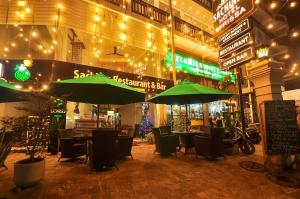 un ristorante con ombrelloni e tavoli e sedie verdi di Sachinro Hotel Mirissa a Mirissa