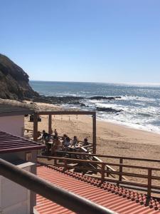 a group of people sitting at a table on the beach at Casa Terraço in São Bernardino