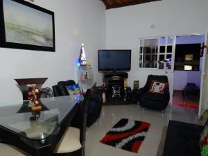 a living room with a table and chairs and a television at APARTAMENTO DE LUJO SAN GIl in San Gil