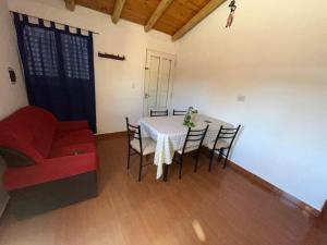 a living room with a table and a red couch at Luci Alojamiento in Uspallata