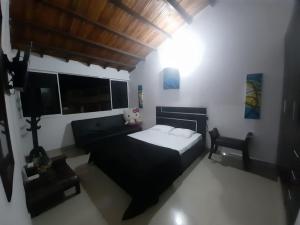 a bedroom with a black bed and a couch at APARTAMENTO DE LUJO SAN GIl in San Gil +37 photos