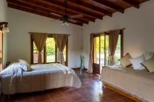 a bedroom with two beds and a ceiling fan at Pour Le Galerie in San Antonio de Areco +29 photos