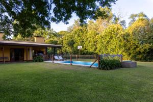 a yard with a pool and a house at Pour Le Galerie in San Antonio de Areco