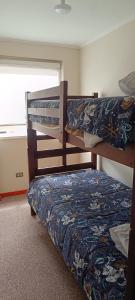 Dos literas en una habitación con ventana. en Departamento Balneario Pelluco, en Puerto Montt