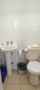 Un baño blanco con inodoro y lavabo. en Departamento Balneario Pelluco, en Puerto Montt